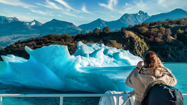 Big Iceberg, people looking at it from the boat, patagonia.