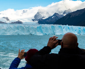 Person from a boat taking a picture of the Perito Moreno glacier.