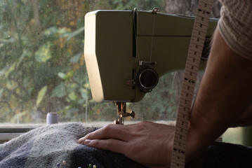 close up of a sewing machine, young man seamstress