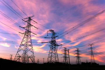 A silhouette of an electric tower against a beautiful sunset background