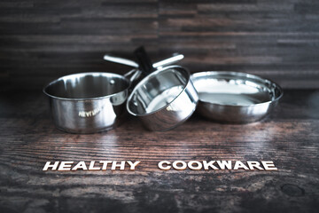 healthy cooking concept, stainless steel pots and pans with Healthy Cookware text in front of them