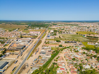 Visão aérea da região central da cidade de Texeira de Freitas, com bairros residenciais,  aera industrial e comercial com a BR101 cruzando a cidade.