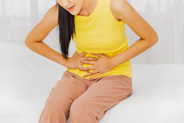 Women with abdominal pain and health care concept : Young beautiful woman touches her stomach,...