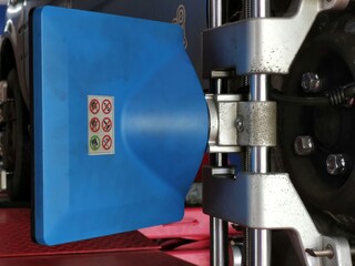 Safety sign sticker on car alignment machine with blurry background. Selective focus.