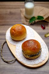 delicious homemade chocolate meses bread and and grated cheese bread, on wooden cutting board. Circle-shaped bread, bakery with a bottle of fresh milk