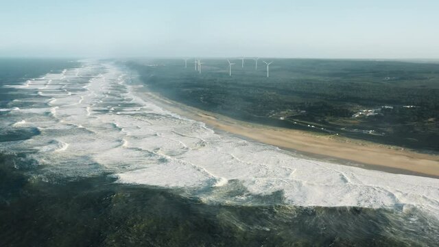Nazare, Portugal. Aerial view of the famous region attracting top surfers from all over the world. Picturesque spit with offshore wind farm in the background. High quality 4k footage