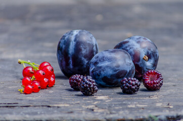 Summer vitamins, delicious berries, blackberries, grapes, plums, blueberries, figs on a wooden background.selective focus