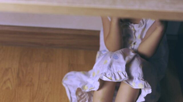 Adorable asian kid girl is crying and sitting under the table with sadness and depression seeing from her stress expression face which is due to bullying or home violence, and lonely abandoned.