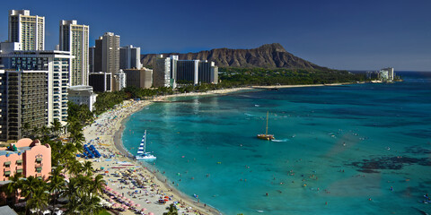 Obraz premium Waikiki Beach Honolulu Hawai'i. A busy day on Waikiki beach with plenty of visitors and local enjoying the beach and ocean.