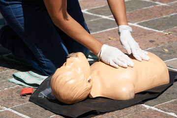 Clase de primeros auxilios enseñando resucitación y respiración boca a boca con un maniqui (rcp)