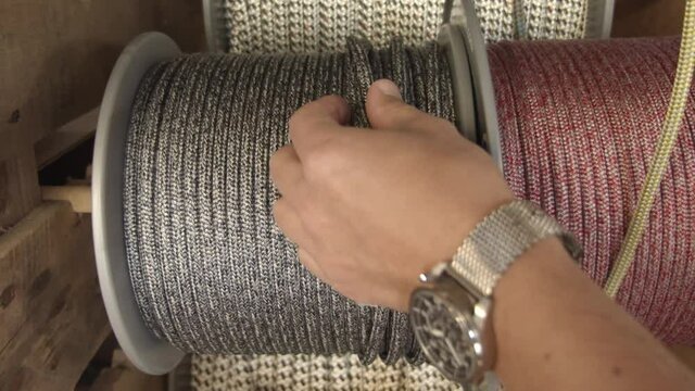 Craftsman choosing silver color rope to make new bracelet, close up view