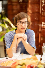 a teenage boy with glasses at the dinner table. children's menu in restaurants. 