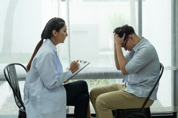 Psychological consultant treatment and healthy concept. Asian psychologist woman and upset man. Asian man feeling stressful talking to the psychologist