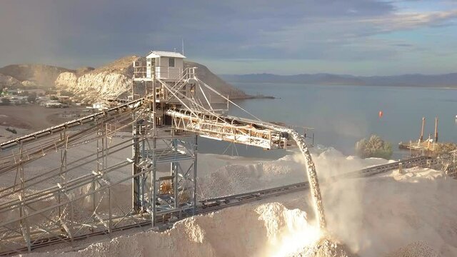 Aerial shot of a conveyor belt offloading plaster gravel at a mining site on San Marcos island in Baja California, Mexico.