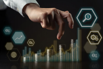 Businessman with coin stack and hologram chart.