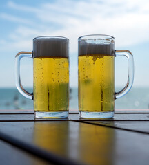 Beer in two glasses - blue sky with white clouds -