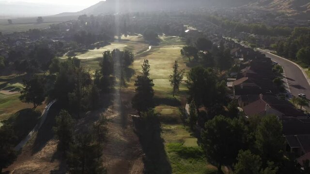 A Golf Course Early Morning With The Sun Shining Over The Course With Green Grass And Trees. 
A Grounds Keeper Walks To His Truck. No Color Grading Done. 3 Of 5