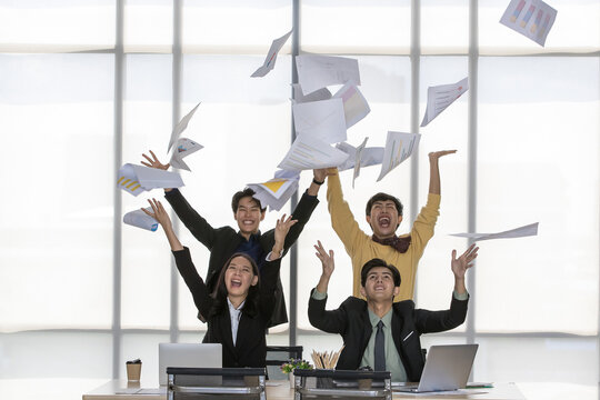 LGBT Asian executive group for transgender community happily celebrate great business achievement by joyfully throwing up paper report of work strategy plan and profit porfolio in conference