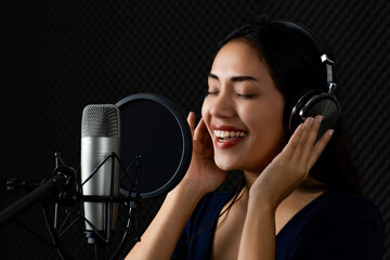 Happy Asain woman as professional singer catching earphone, smile, enjoy practicing attractive...