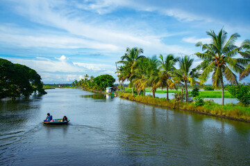 Fisher man paddling a coracle boat (Kotta vanchi) at Kadamakkudy lake during day time, Kerala backwaters photography