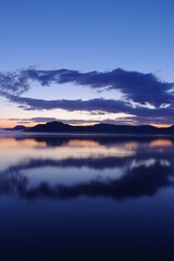Naklejka na ściany i meble 夜明けの空を湖面に反射する湖。日本の北海道の屈斜路湖で。