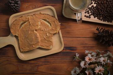 Above view toast bread with peanut butter on wooden background.