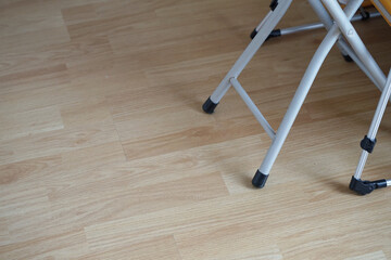 Plastic chair, leg, and base on a laminate floor.