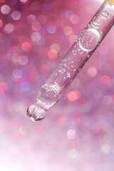 A drop of cosmetic oil falls from the pipette