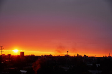 Sunset over city with buildings silhouette