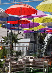 Obraz na płótnie Canvas colored umbrellas instead of a roof over a cafe, a fun decoration