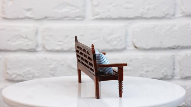 Miniature toy on wall background. Close up view of wooden toy furniture against wall background