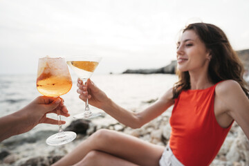 Portrait of young woman with cocktail glass chilling on a beach