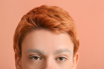 Teenage boy with dyed eyebrows on color background, closeup