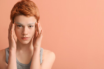 Fototapeta premium Teenage boy with dyed eyebrows on color background