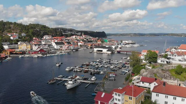 Hill island sea side city view with port at Kragero, Norway - aerial drone flying forward shot