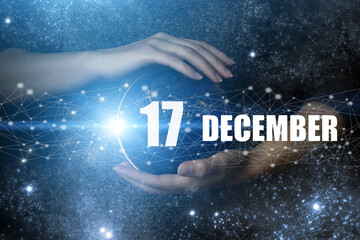 December 17th. Day 17 of month, Calendar date. Human holding in hands earth globe planet with...