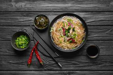 Composition with tasty Chinese soup on dark wooden background
