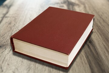 old brown book with worn gilded paper edges on the desk