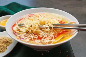 Bowl of tasty Thai soup on dark background, closeup