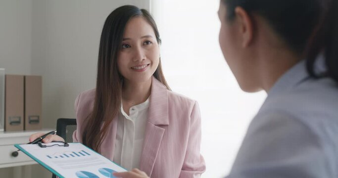 Asia stock trader agent or Sale tax loan broker advice brief and point hand to graph report talk to client at office desk show budget chart data or legal result on claim form. Trust will in work plan.