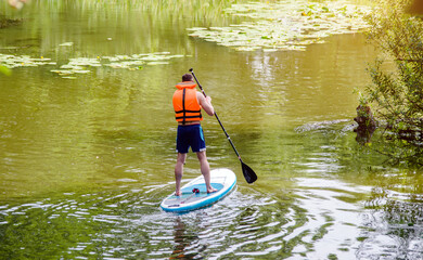 A guy engaged in kayaking standing on a board
