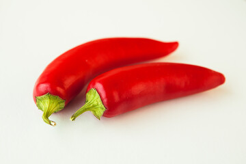 Two hot chili peppers on white background
