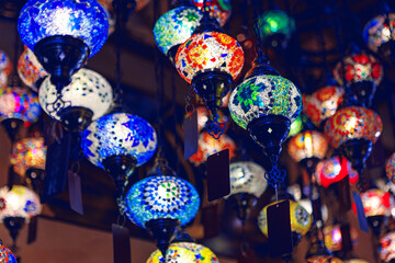 Middle Eastern lamps of different colors hanging in bazaar