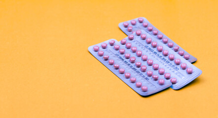Blister packs of contraceptive pills on yellow background. Hormone pills for treatment hormone acne. Birth control pills. Estrogen and progesterone hormone pills. Pharmacy banner. Prescription drugs. - obrazy, fototapety, plakaty