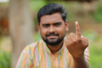 Young Indian farmer showing finger after voting. voting sign in india