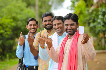 Young Indian farmers showing finger after voting with officers.
