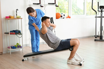Fototapeta premium Female physiotherapist working with patient in rehabilitation center