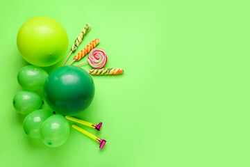 Air balloons, noisemakers and lollipops on color background