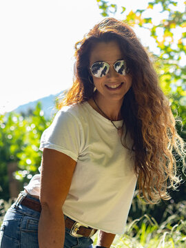 Smiling woman with long hear wearing sunglasses