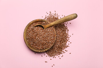Bowl with flax seeds on color background